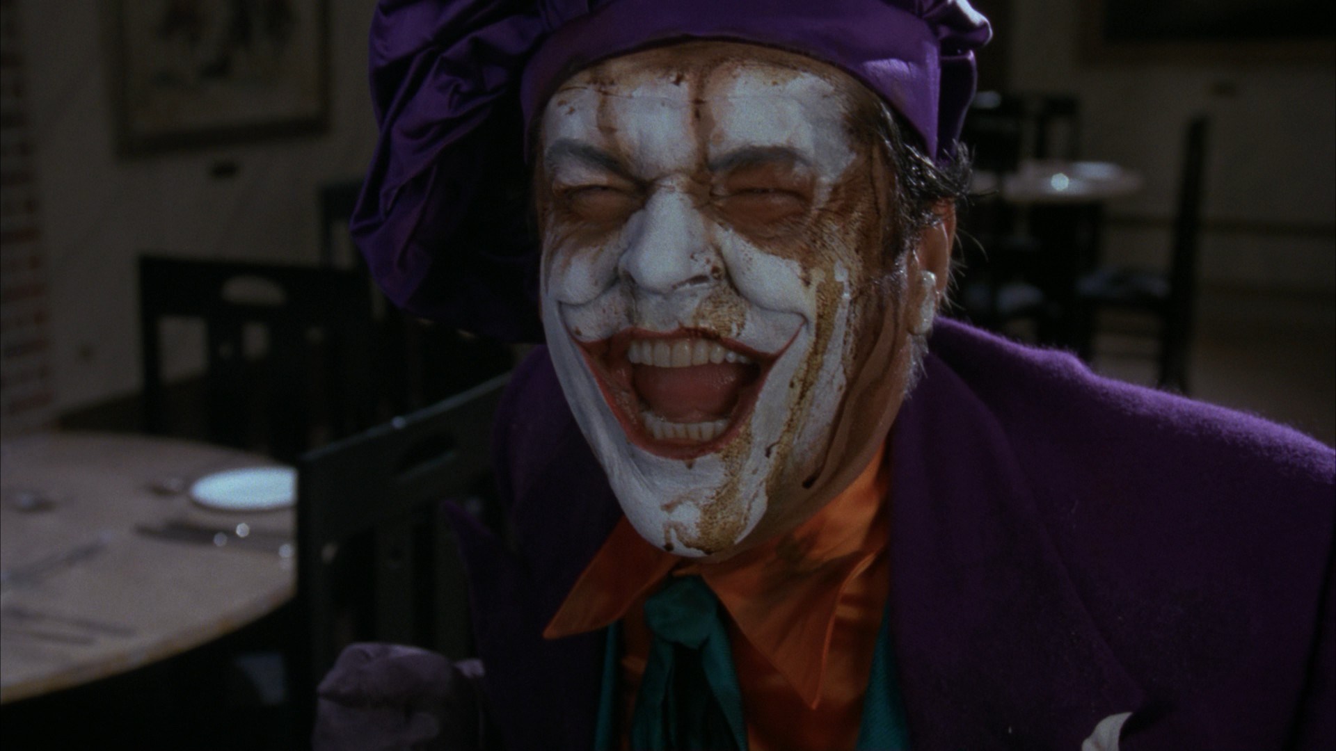 The Joker laughs, liquid dripping down his face.