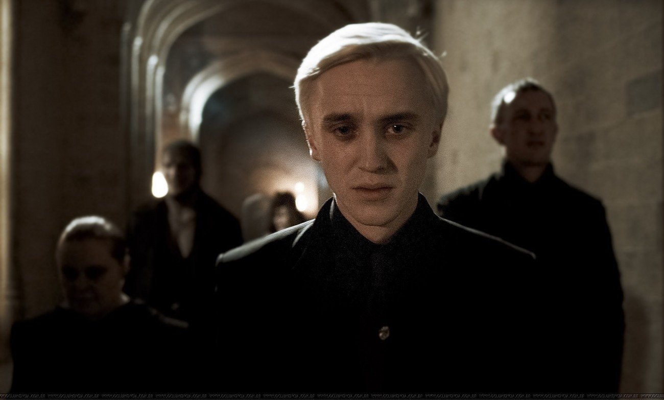 Draco Malfoy walks in Hogwarts, looking sad and hopeless.