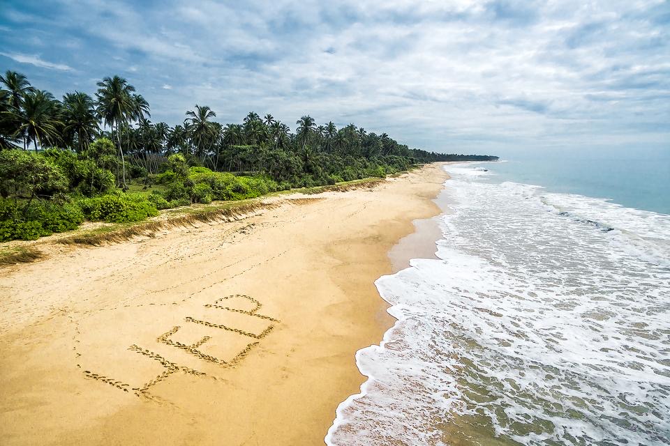 The message "help" written on the sand of a deserted island