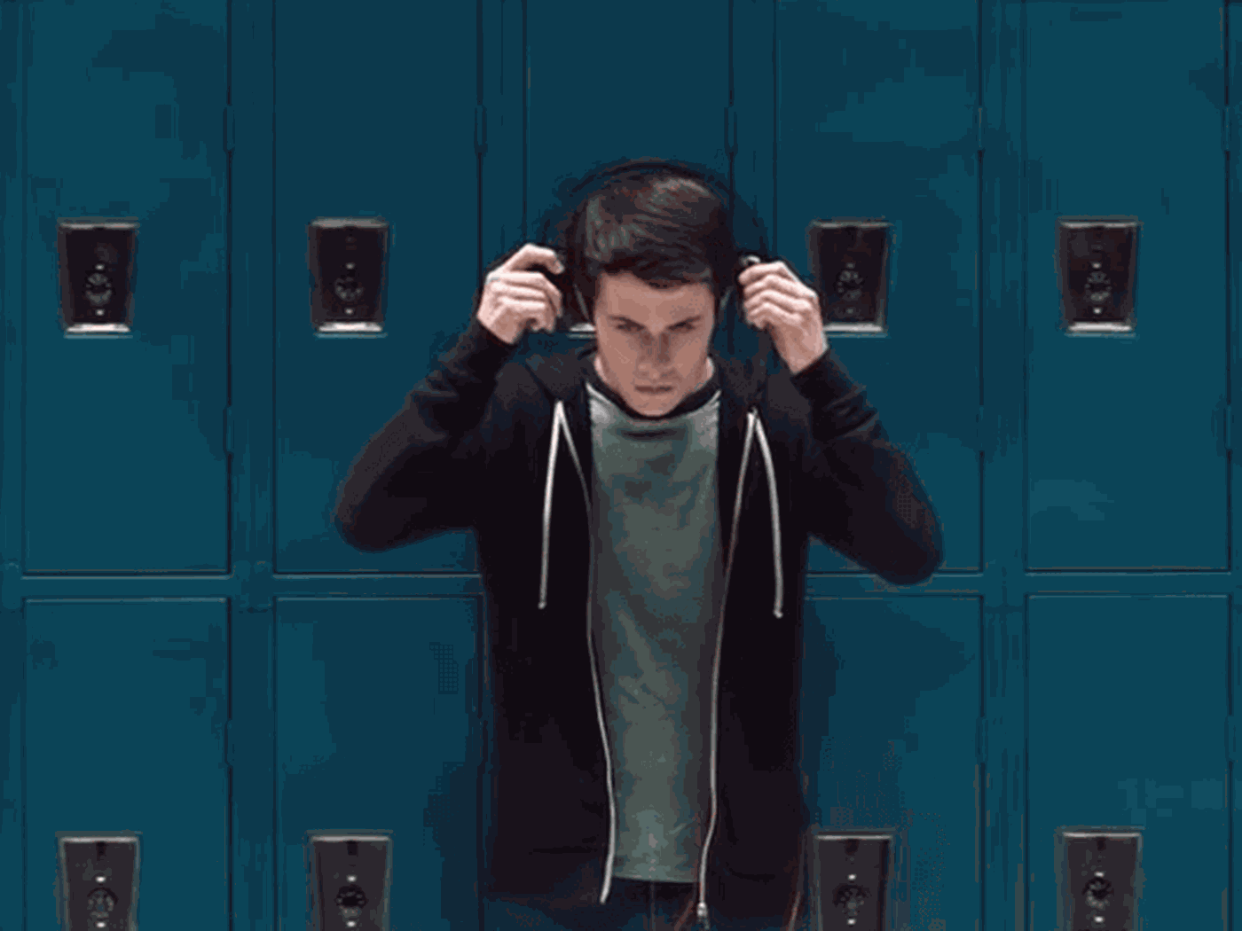 Clay Jensen putting on headphones in front of lockers. 