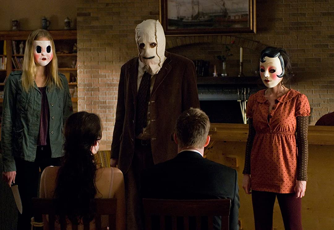 The three killers from The Strangers facing the couple near the end of the movie.