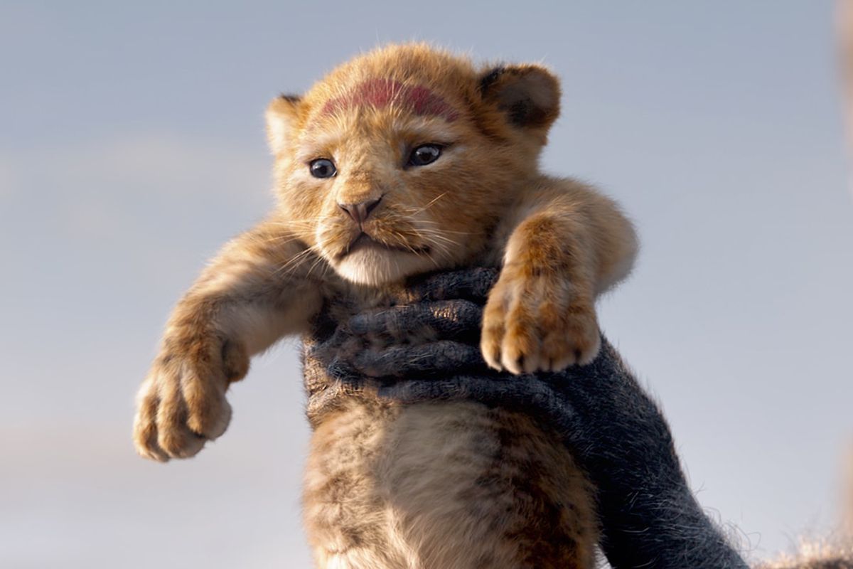 A CGI Simba is held up by Rafiki.