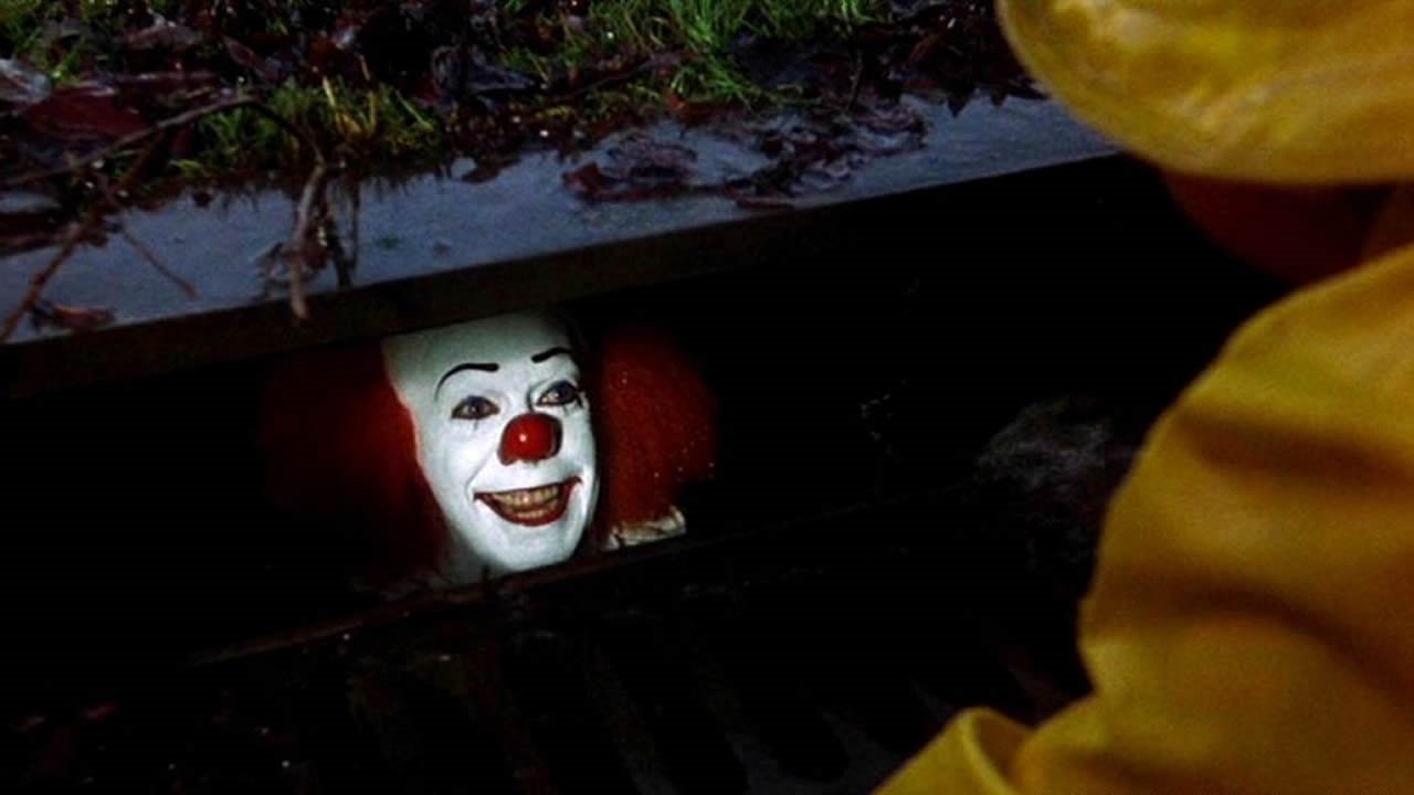 Tim Curry as Pennywise The Clown in a sewer in the movie It.