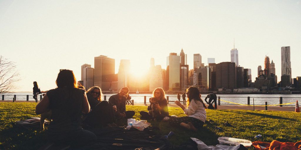 A group of friends at a park sitting and chatting.