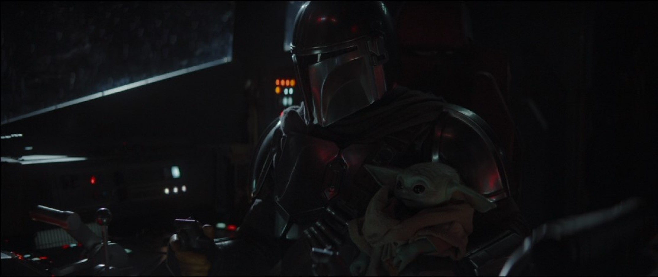 Star Wars characters the Mandalorian and Baby Yoda sit in the Razor Crest ship.