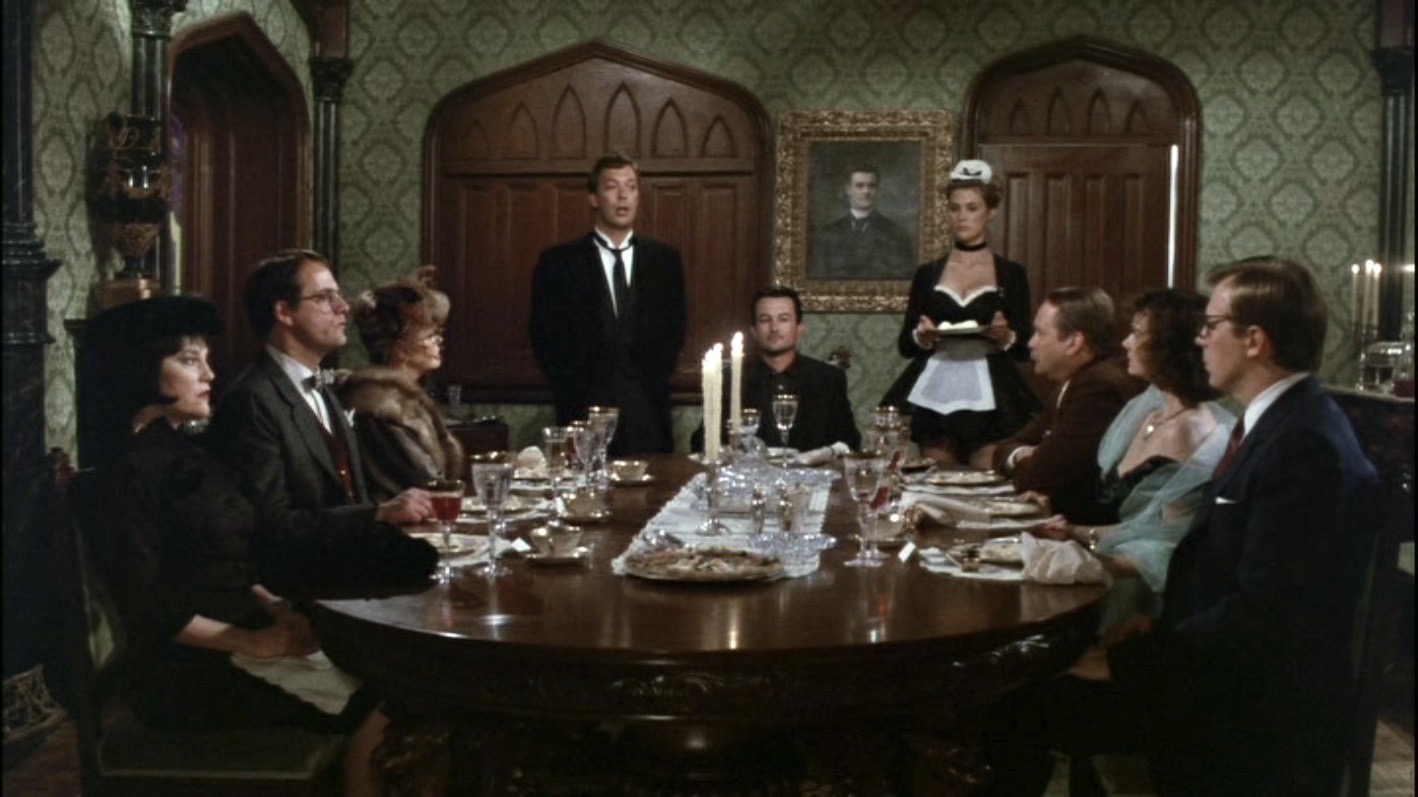 The guests sit at the dinner table with Mr. Boddy at the head. Wadsworth and Yvette stand.