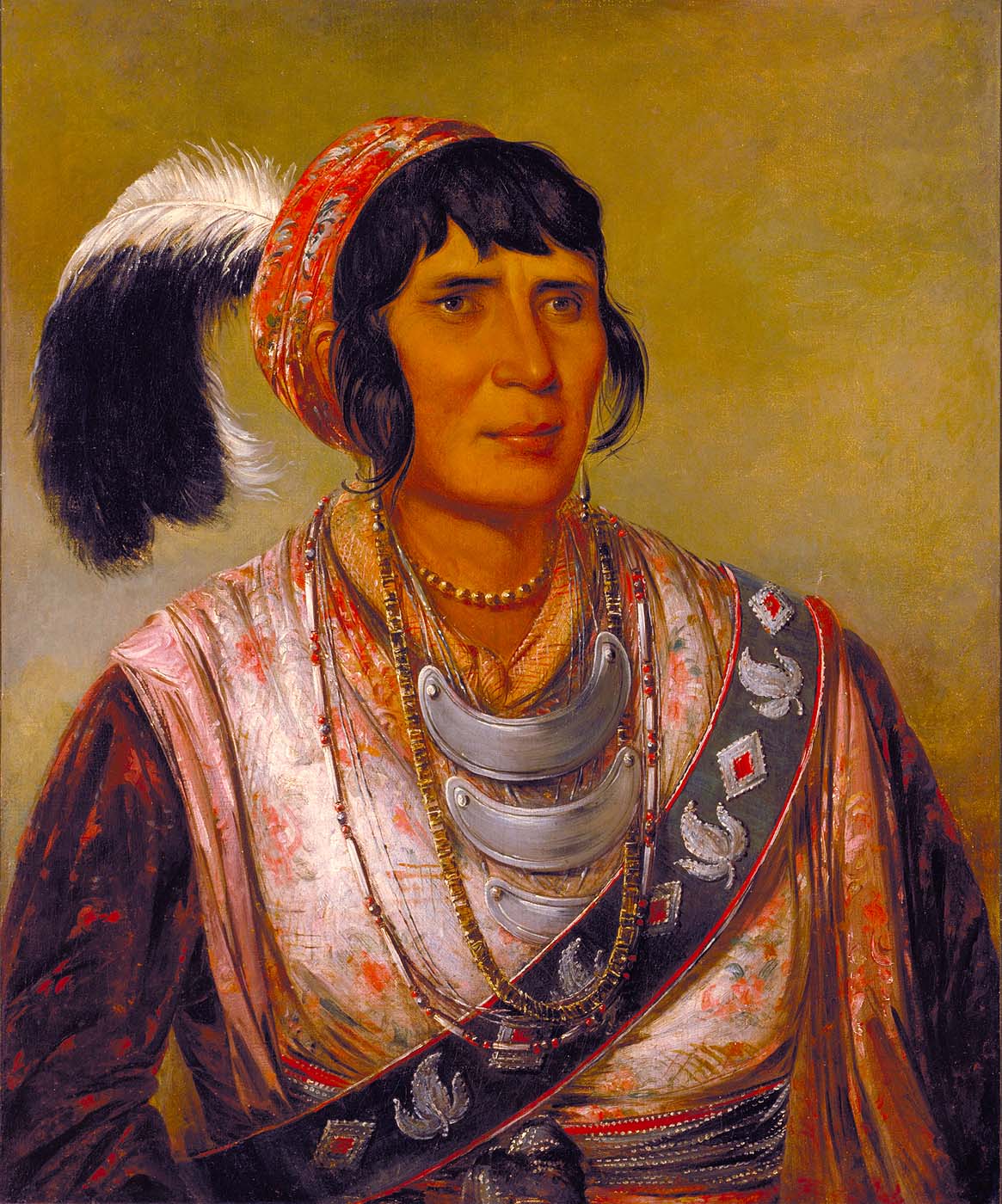 A portrait of Seminole leader Osceola, called "Os-ce-o-lá, The Black Drink, a Warrior of Great Distinction" by Geroge Catlin. Osceola wears colorful robes, a headband holding three feathers, and three ceremonial gorgets draped around his neck. 