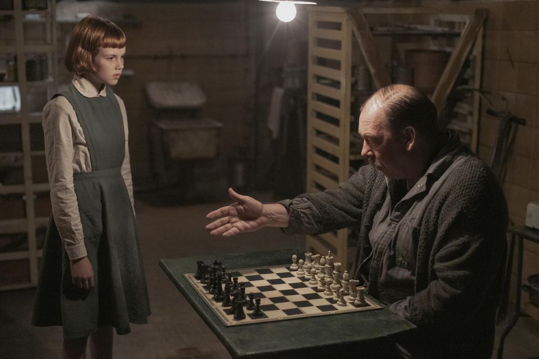 oung Beth Harmon (Isla Johnston) and Mr. Shaibel (Bill Camp) are having a conversation in the basement of the orphanage while hovering over the chess board.
