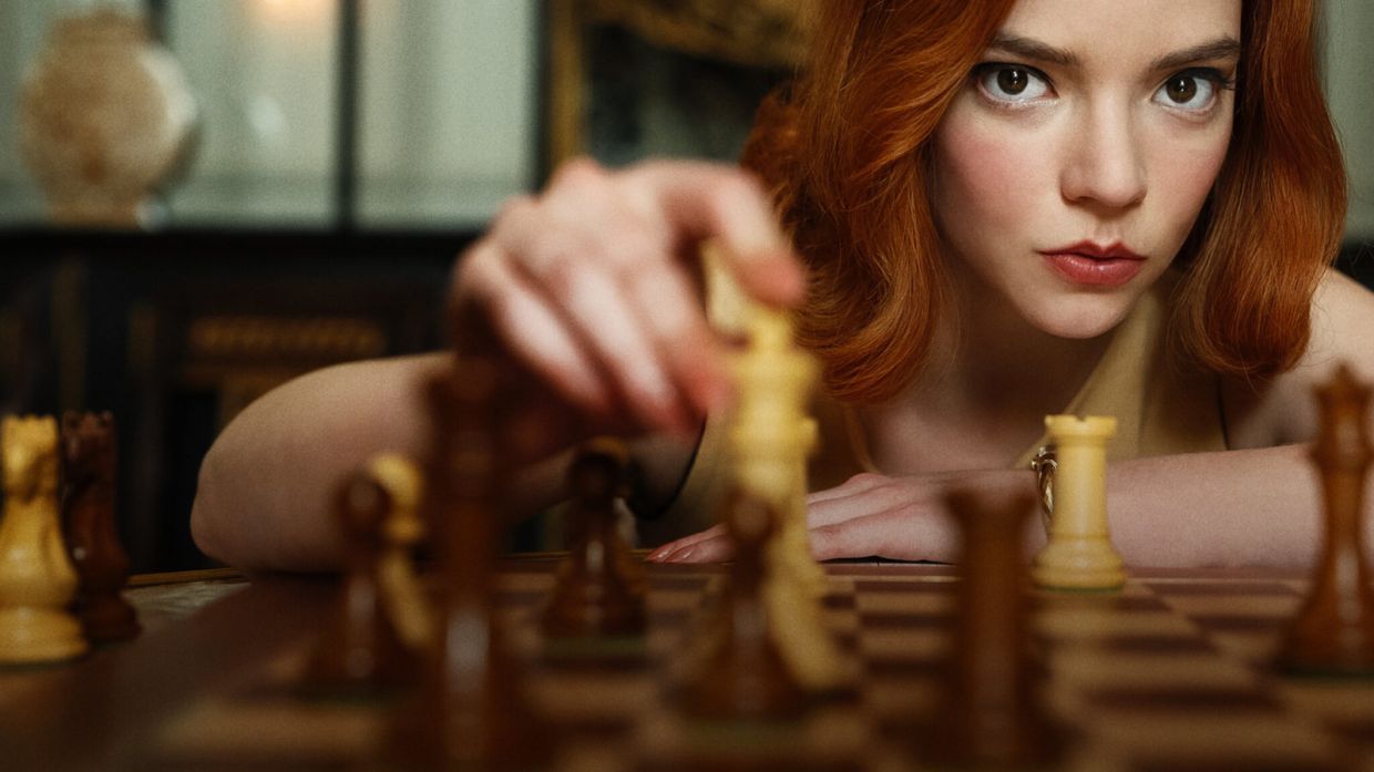 "The Queen's Gambit" character Beth Harmon, played by actress Anya Taylor-Joy moves a chess piece across a playing board.