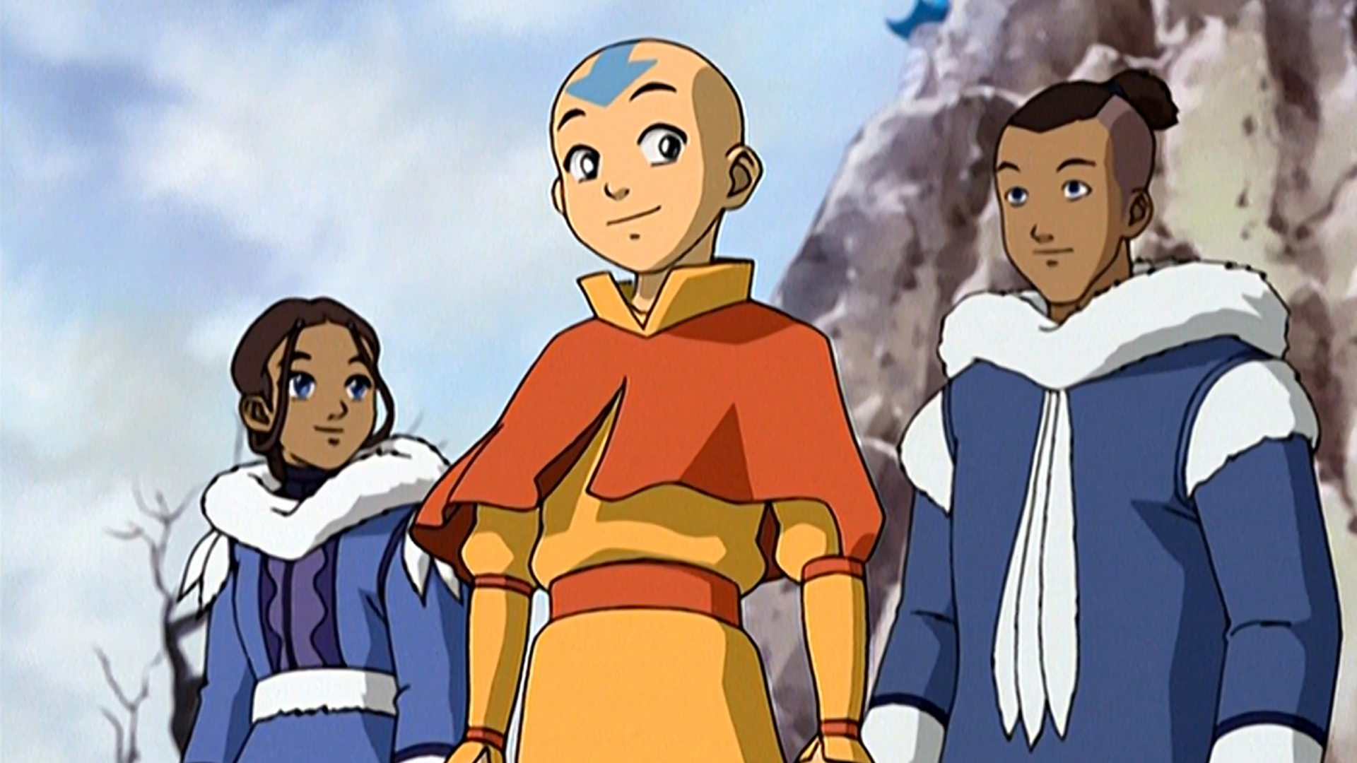 Aang stands with Sokka and Katara near a snowy cliffside.