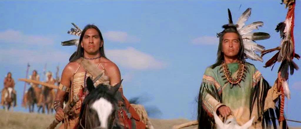 Indigenous actors Graham Green (Right) and Rodney A. Grant (Left) portray Kicking Bird and Wind In His Hair in the 1990 film Dance With Wolves. Grahm and Rodney wear traditional native garb as they sit astride horses on the movie set.