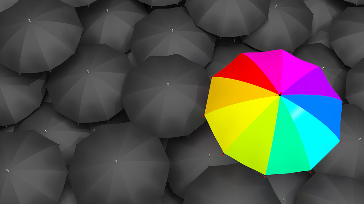 A rainbow umbrella among grey umbrellas to signify the experience of being in the LGBTQ+ community.