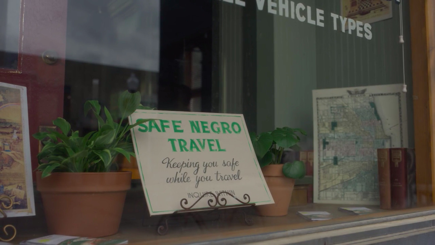 A sign reads, "Safe Negro Travel," in the window of George Freeman's business. 