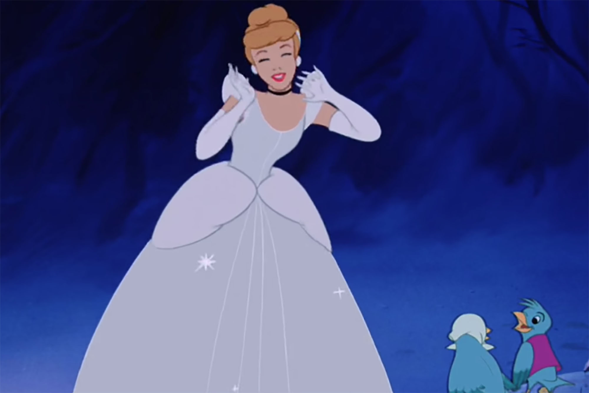 Cinderella stands near a fountain in ball gown.