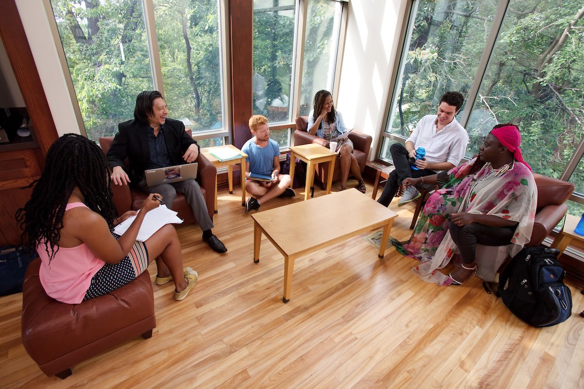 Writers sit in a semi-circle, listening to someone speak.