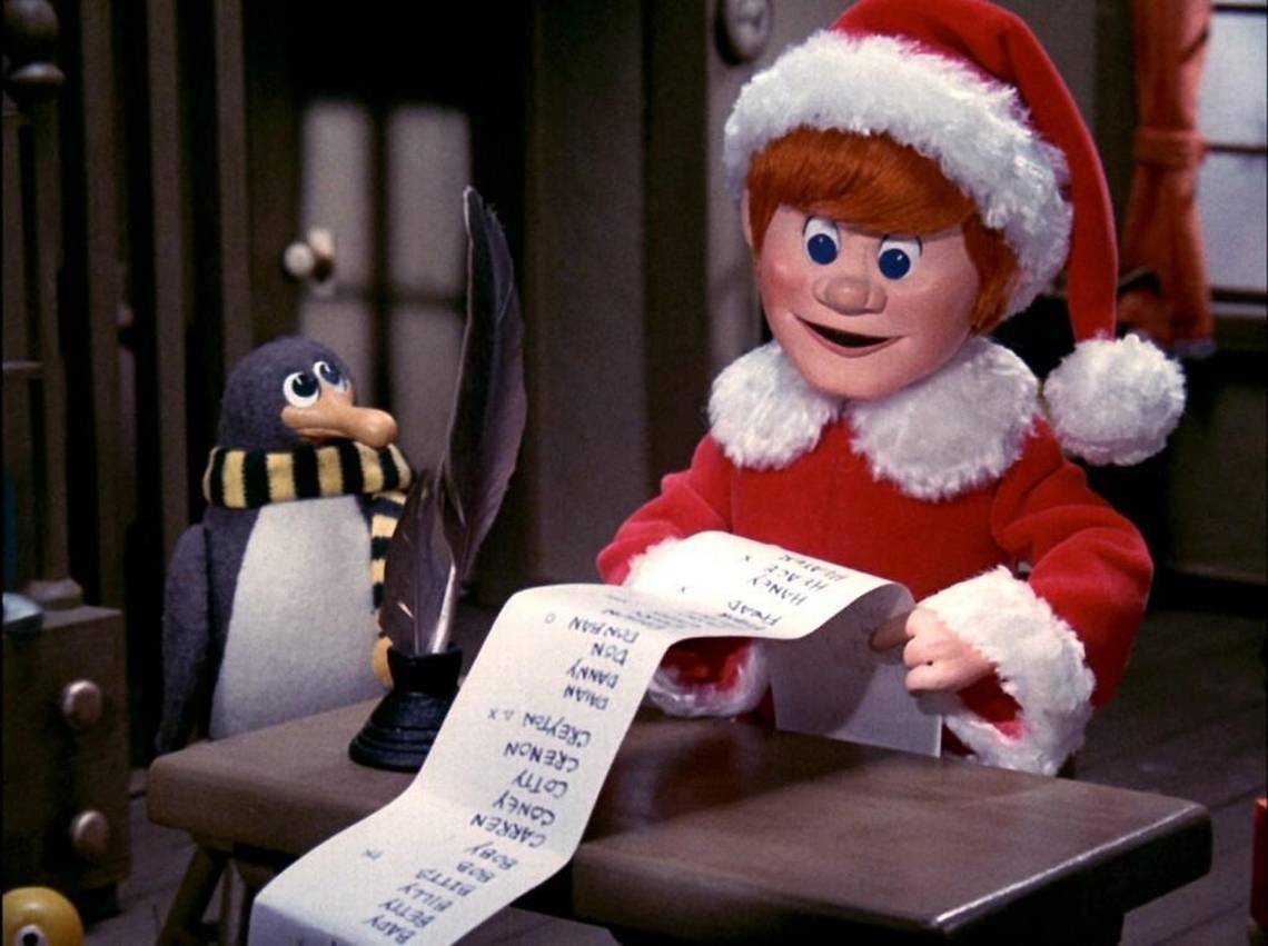 Kris Kringle and Topper, the penguin, look over a long list.