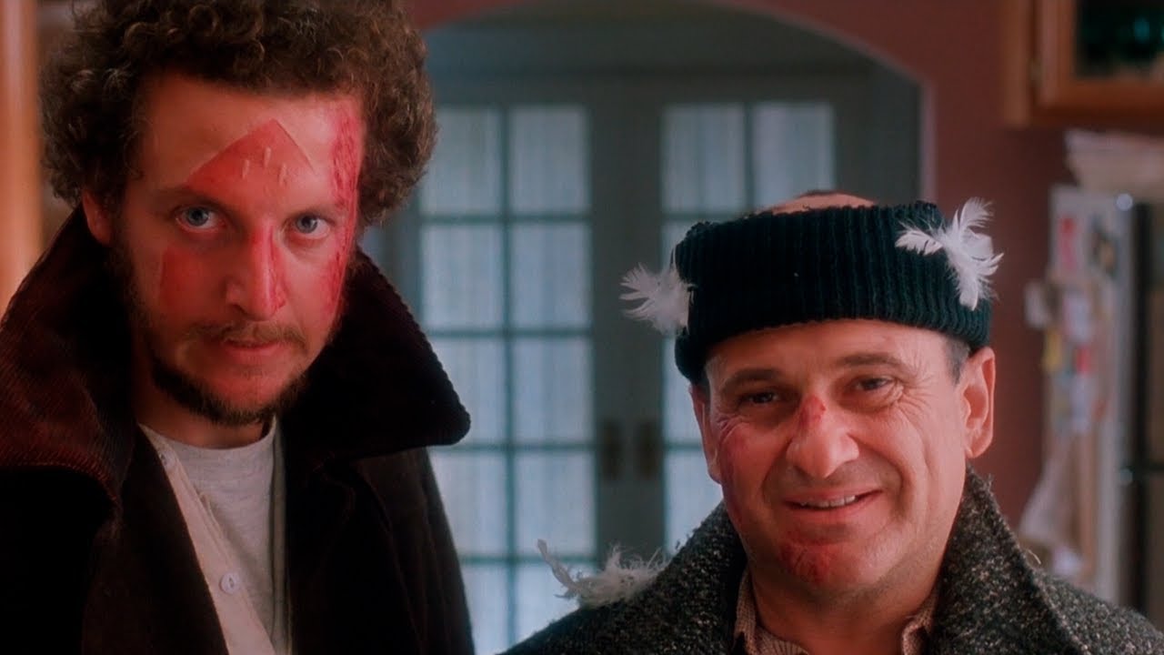 The Wet Bandits look at the camera. Marv has the red imprint of an iron on his face and Harry has burns and feathers on his head. 
