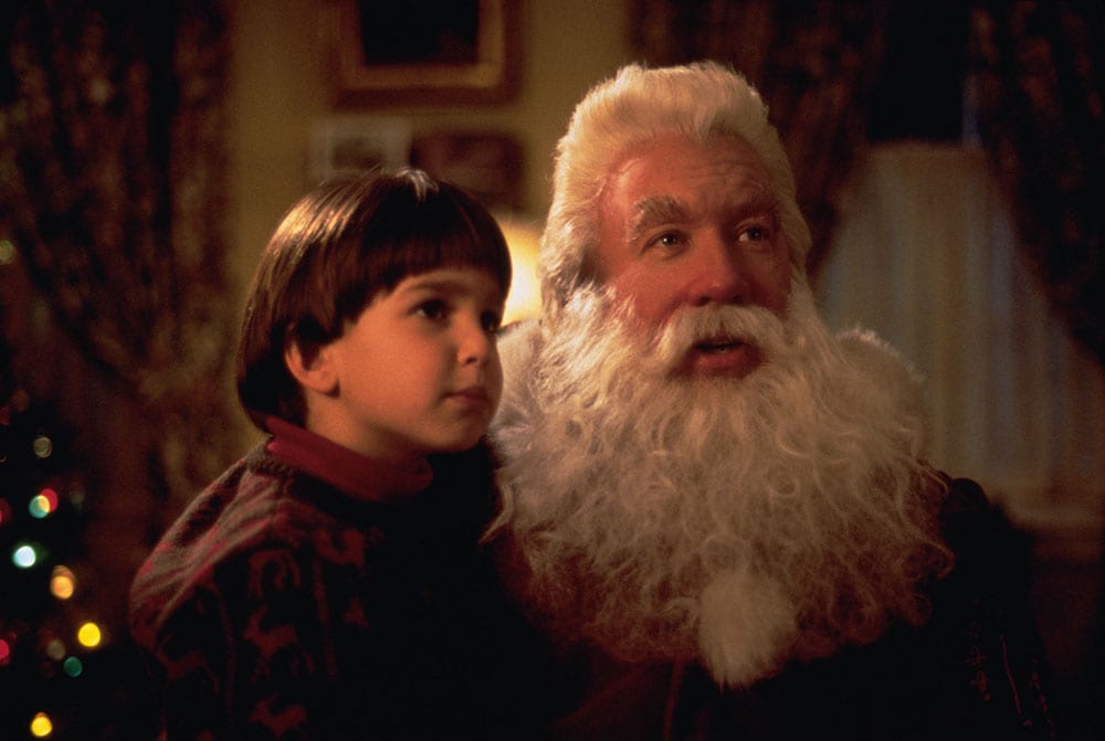 Tim Allen as Santa Claus and his son, Charlie, look at someone off-camera.