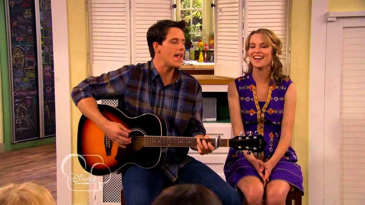 Possibly one of Disney's most toxic couples, Spencer and Teddy sit side by side and sing together. Spencer holds a guitar.