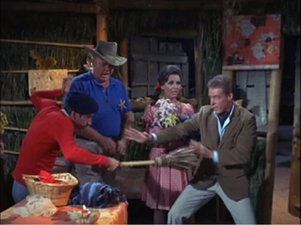 Gilligan fends off the Professor with a broomstick while the Skipper and Mary Ann watch in horror from Sherwood Schwartz's Gilligan's Island, 1964-1967. (Photo by CBS Photo Archives)