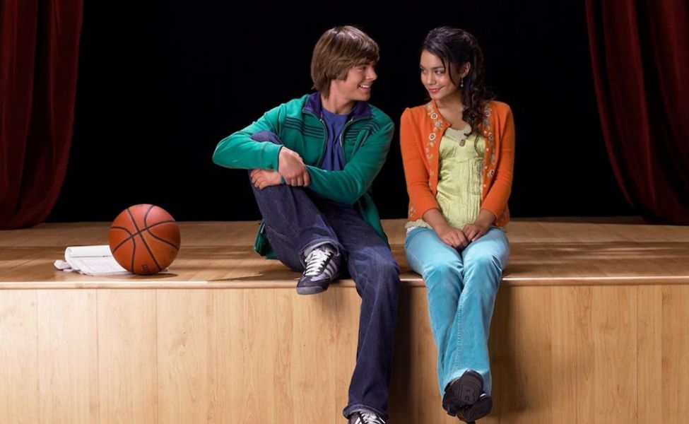 Troy and Gabriella sit beside each other on stage. Their perfect facade hides the fact that they're one of Disney's many toxic couples.