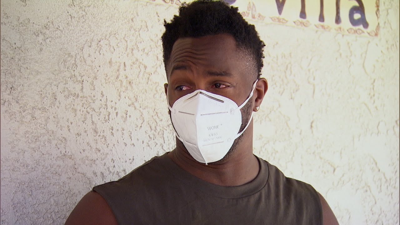 Contestant Eazy, on The Bachelorette, sporting a medical face mask on set.