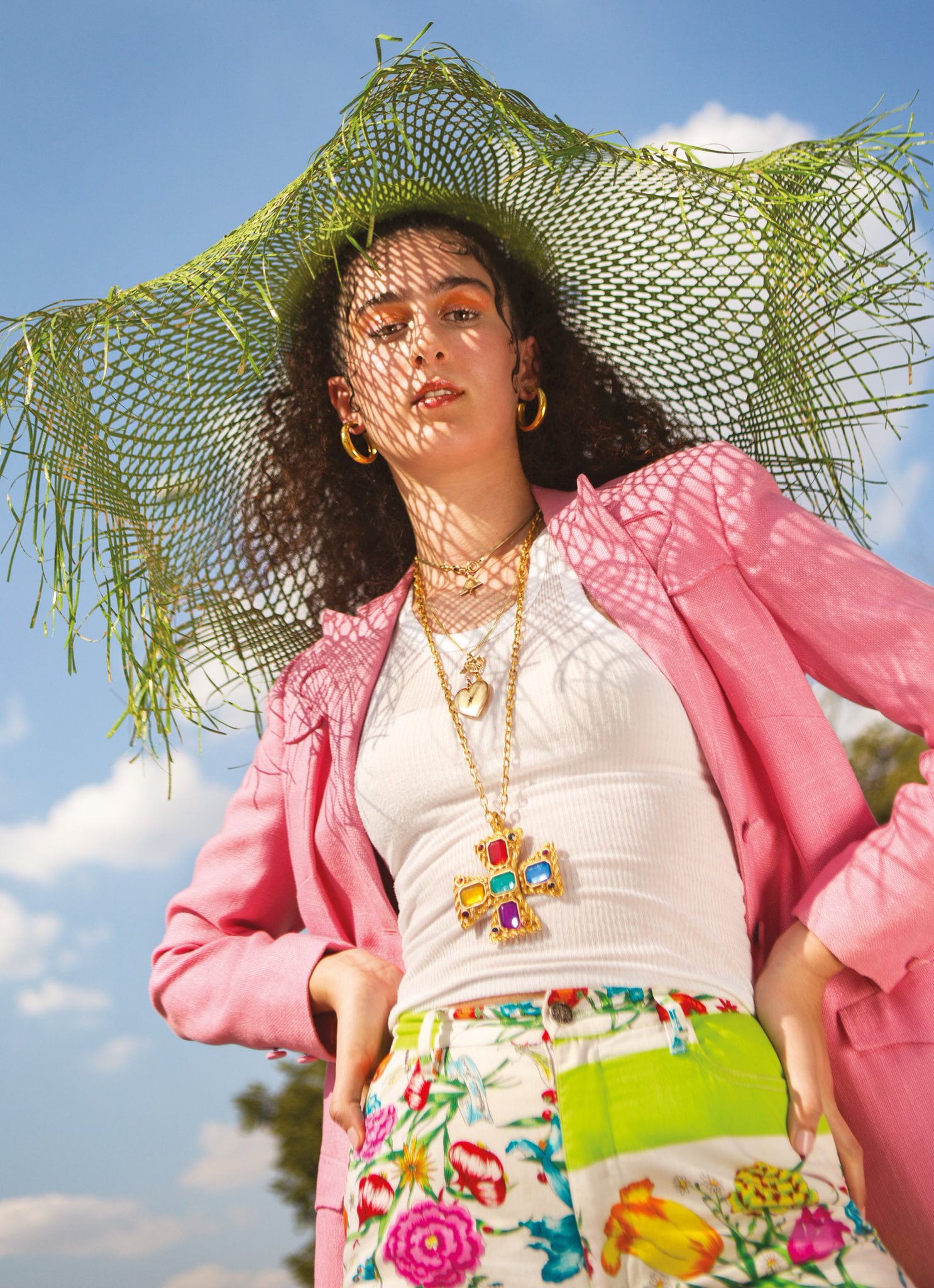 Olivia in funky clothing, with the sky in the background, on set in a collaboration with Depop.