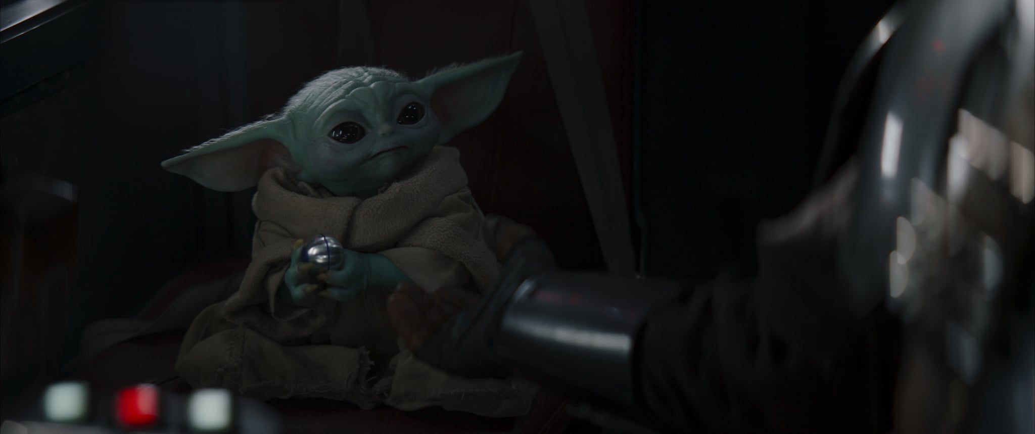 Baby Yoda holding his favorite toy, a piece off of Mandorian's ship.