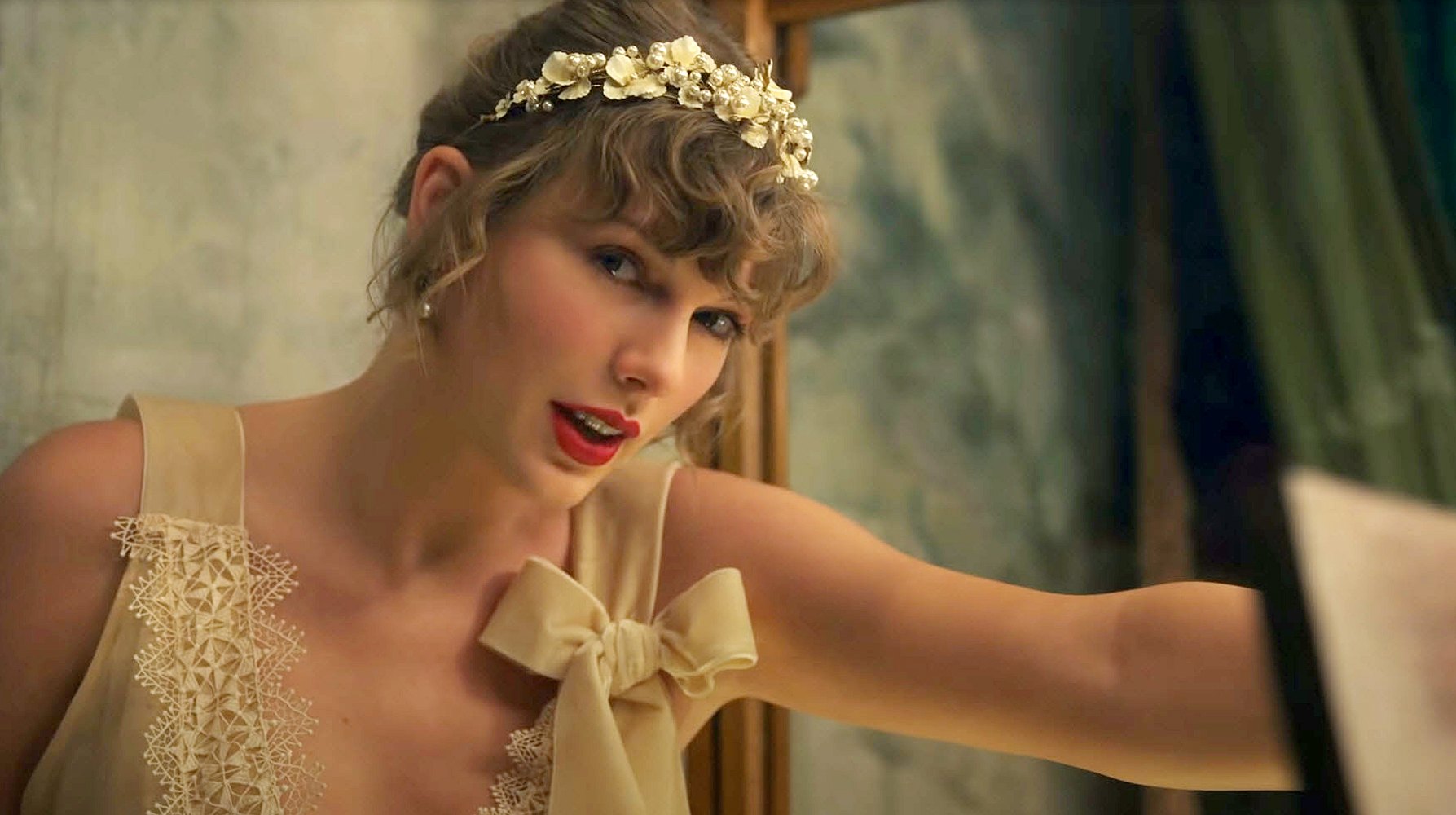 Taylor descending into a secret latch while wearing a wedding dress in the willow music video.