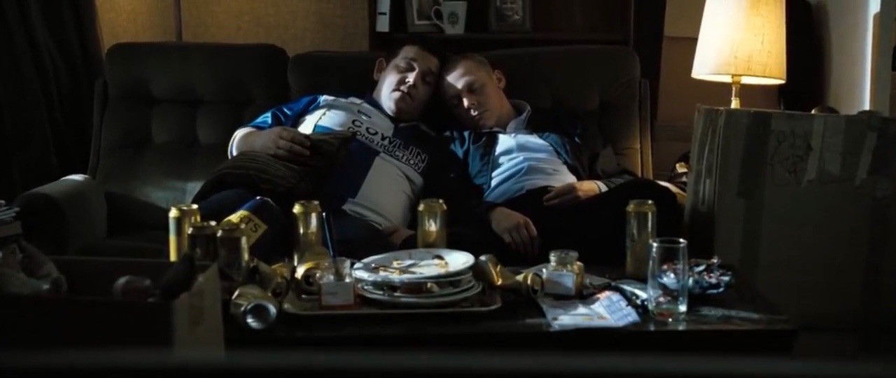 Nicholas (right) and Danny (left) asleep on a couch, their heads touching. 