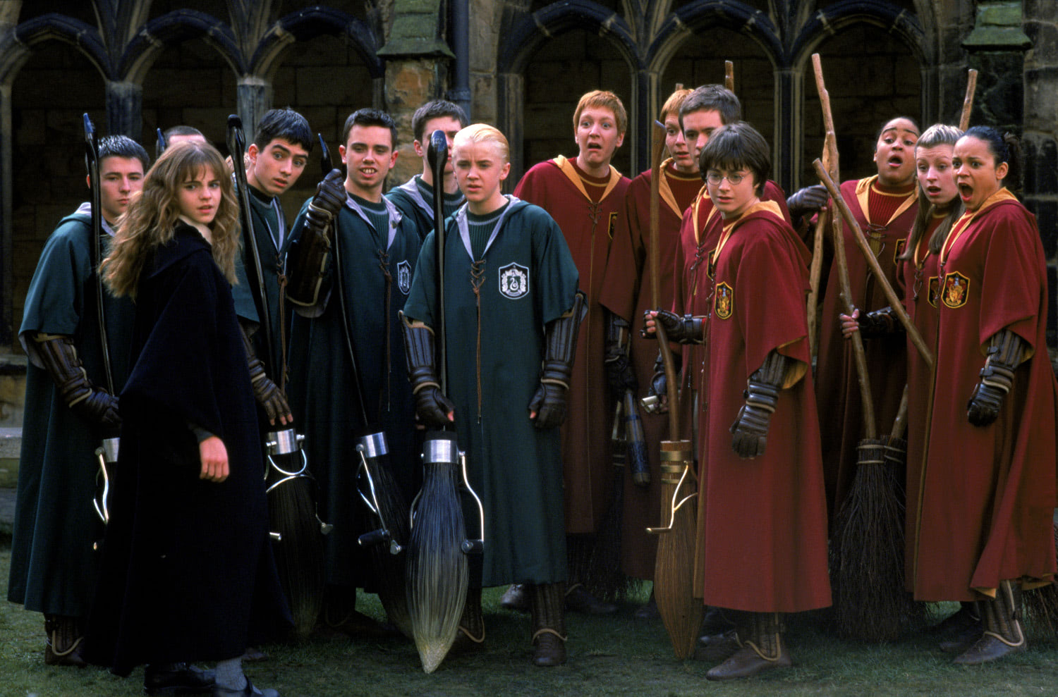 Gryffindor and Slytherin's Quidditch teams side by side in the Hogwarts courtyard, along with Hermione