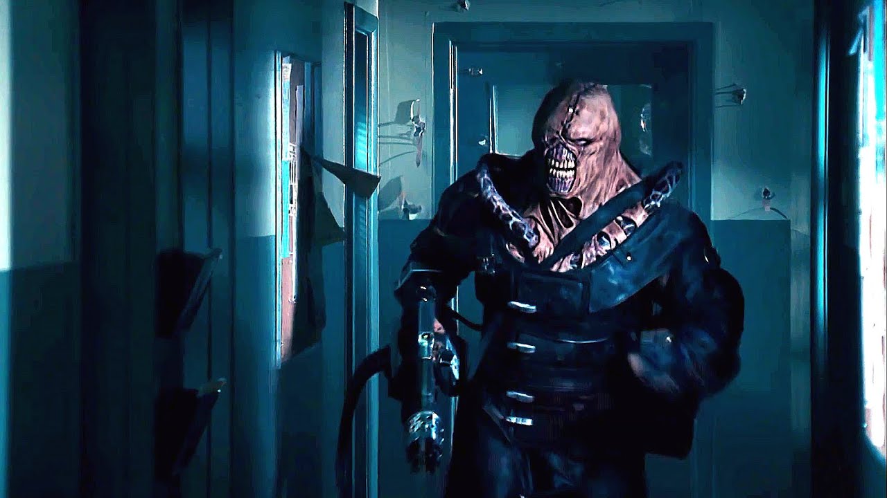 Media: A shot of Nemesis from Resident Evil 2: Apocalypse. He is a large, humanoid monster. He is running down a dim hallway and carries a large gun. The practical effects that make up Nemesis's costume are less than quality, hinting at how bad this piece of media might be.