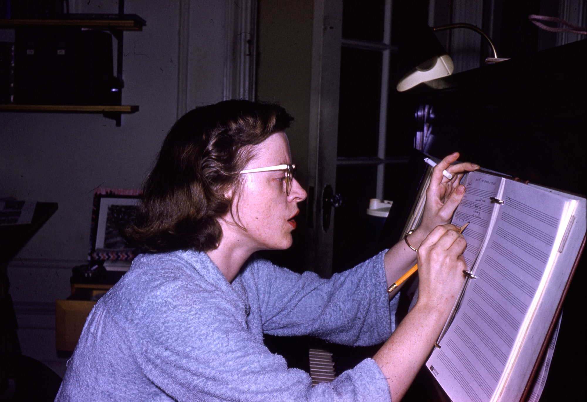 Connie Converse writes down notes onto a blank music sheet with a cigarette in her hand and a furrowed brow. (Photo by Elizabeth Converse/The Estate of Elizabeth Converse/Squirrel Thing Recordings)