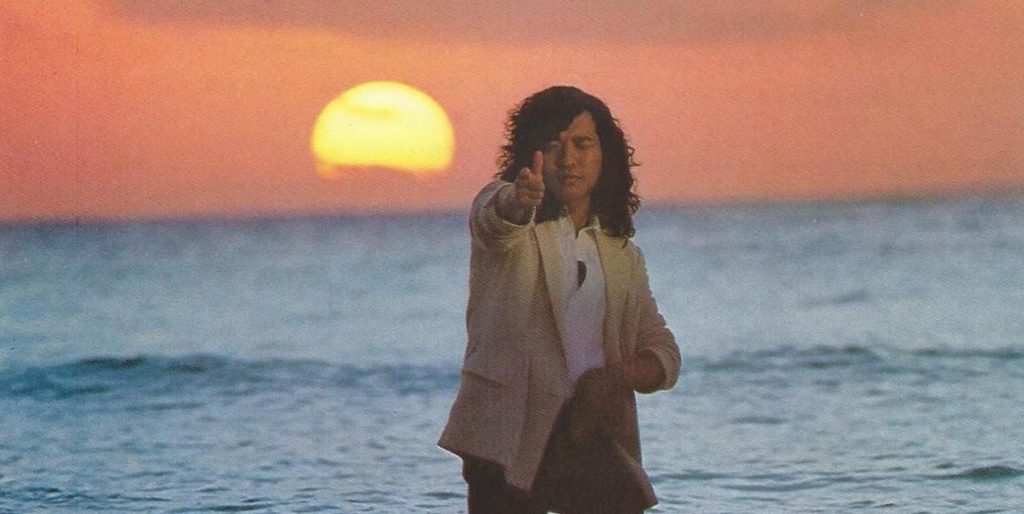 "Ride On Time." Tatsuro Yamashita. 1982. (This is a photo of Yamashita. He is pointing at the camera, in front of the ocean at sunset.)