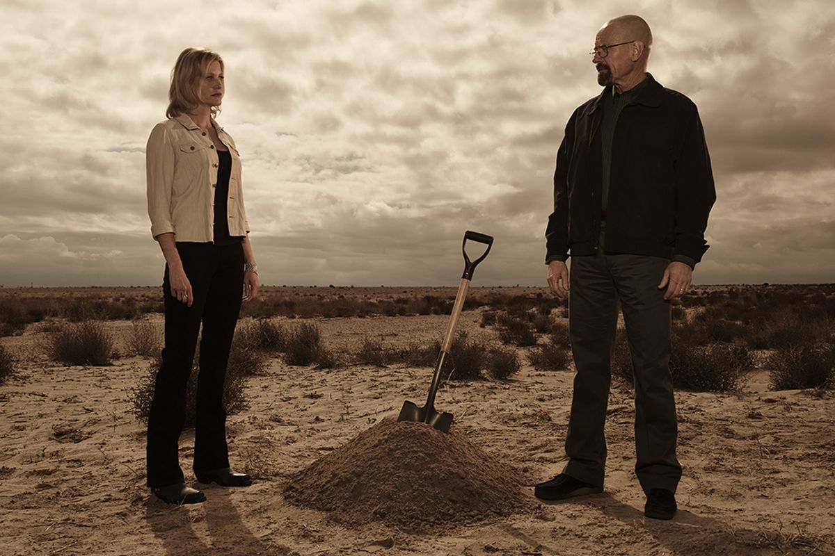 Skyler White and Walter White are standing in the New Mexico desert between a shovel that's embedded in a pile of dirt.