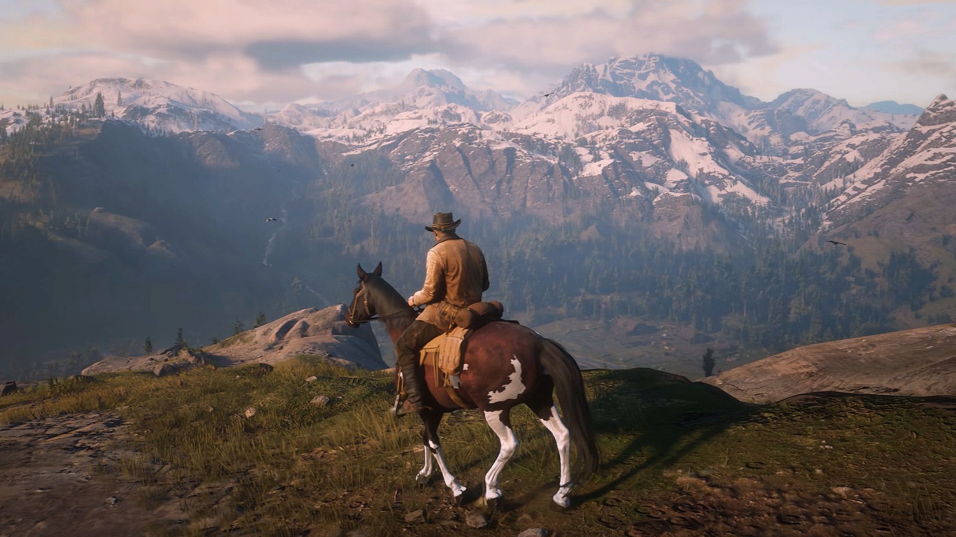 "Red Dead Redemption 2's" main character, Arthur Morgan, sitting on a horse looking at a vast mountain range.