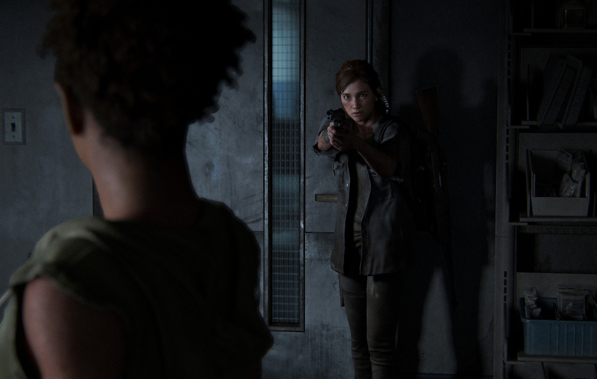 "The Last of Us Part II" main character Ellie stands in a dark room and aims a gun at another character.