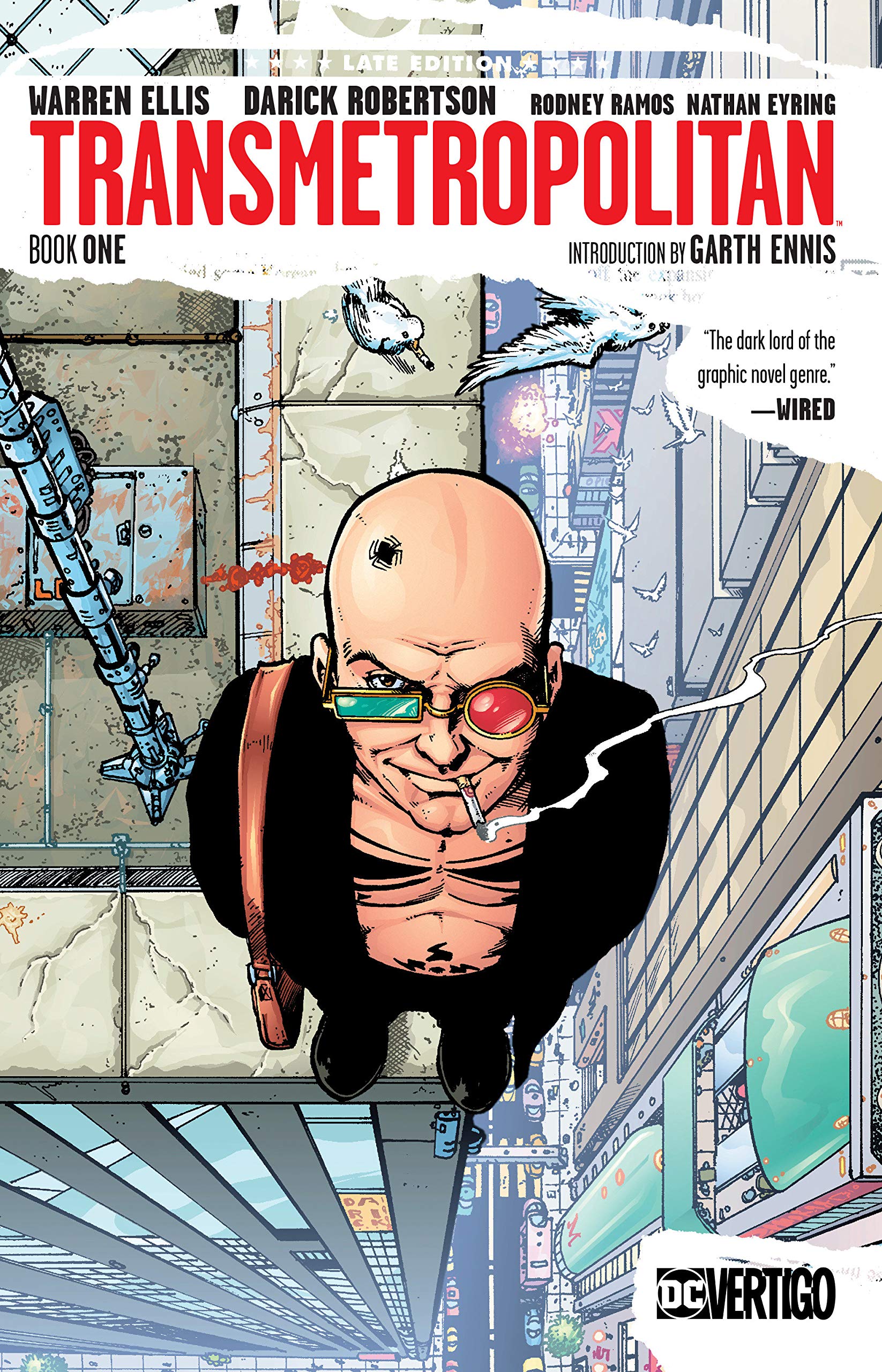 Spider Jerusalem stands at the very edge of a tall building wearing his patented green and red glasses. He is wearing a black jacket with no shirt underneath and smokes as he seems to stare right out at you.