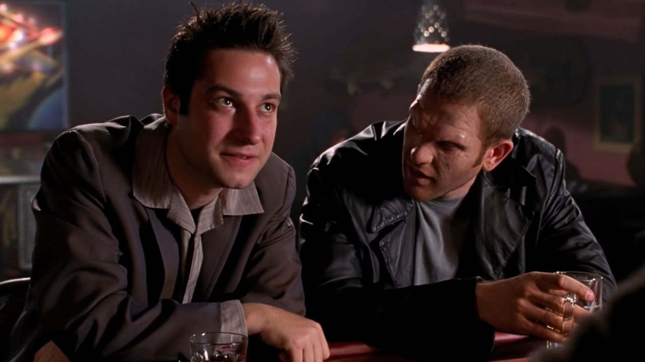 Warren sits at a demon bar bragging about his actions in a shot from Buffy the Vampire Slayer, 1997-2003 (Photo by Mutant Enemy Productions/20th Century Fox).