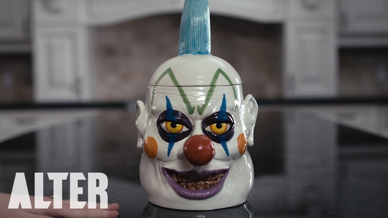 Image of a clown toy on a table. Kookie. YouTube, uploaded by Alter. 6 Sep. 2019.