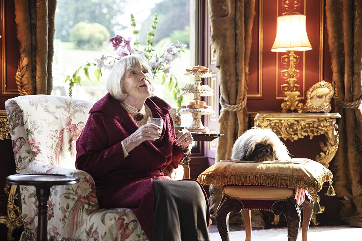 Mrs. Pumphrey sits with Tricki Woo in a shot from All Creatures Great and Small, 2020. (Photo by Playground Entertainment/PBS).