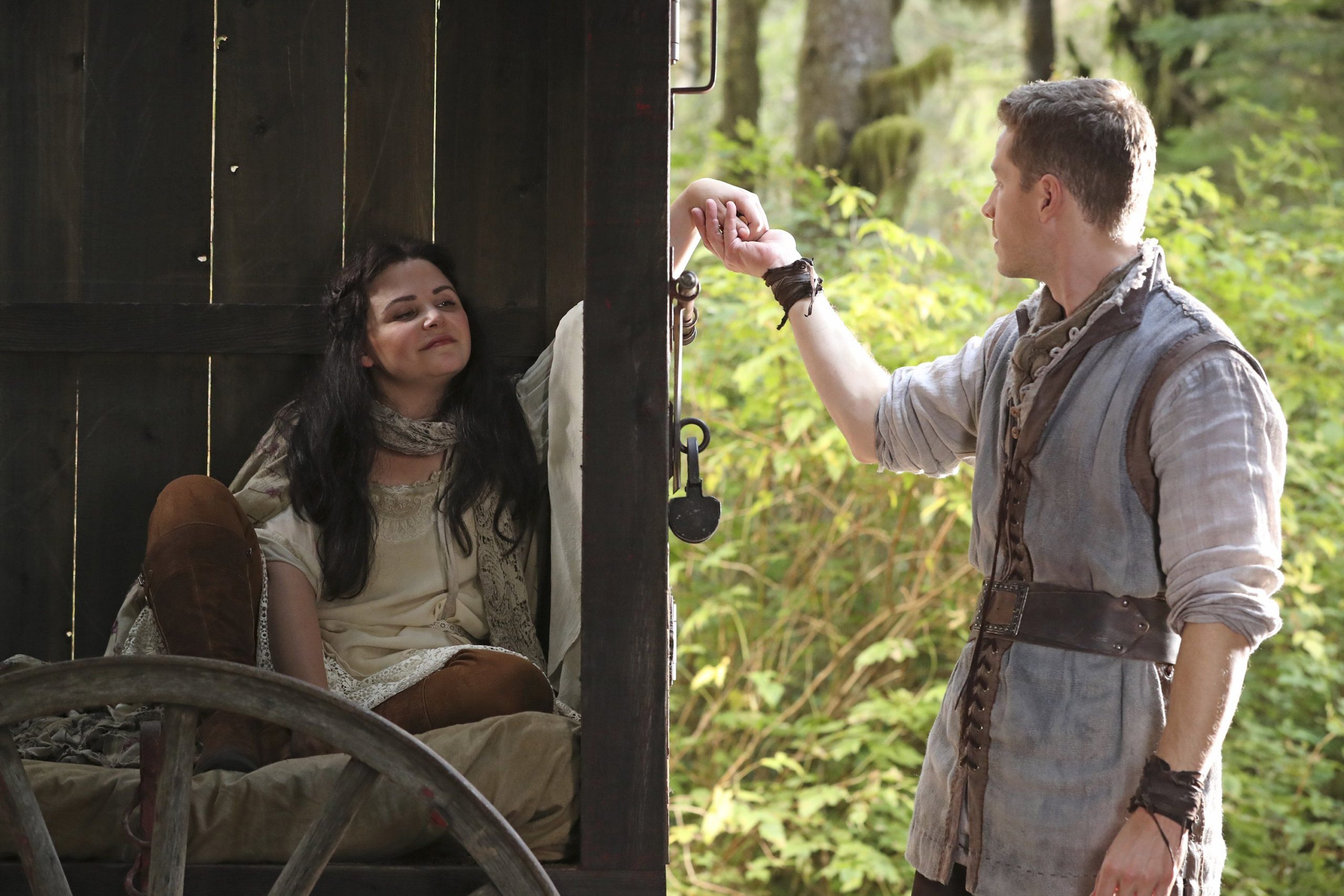 Snow White and Prince Charming are touching hands as Snow sits in a carriage, creating barrier between them.