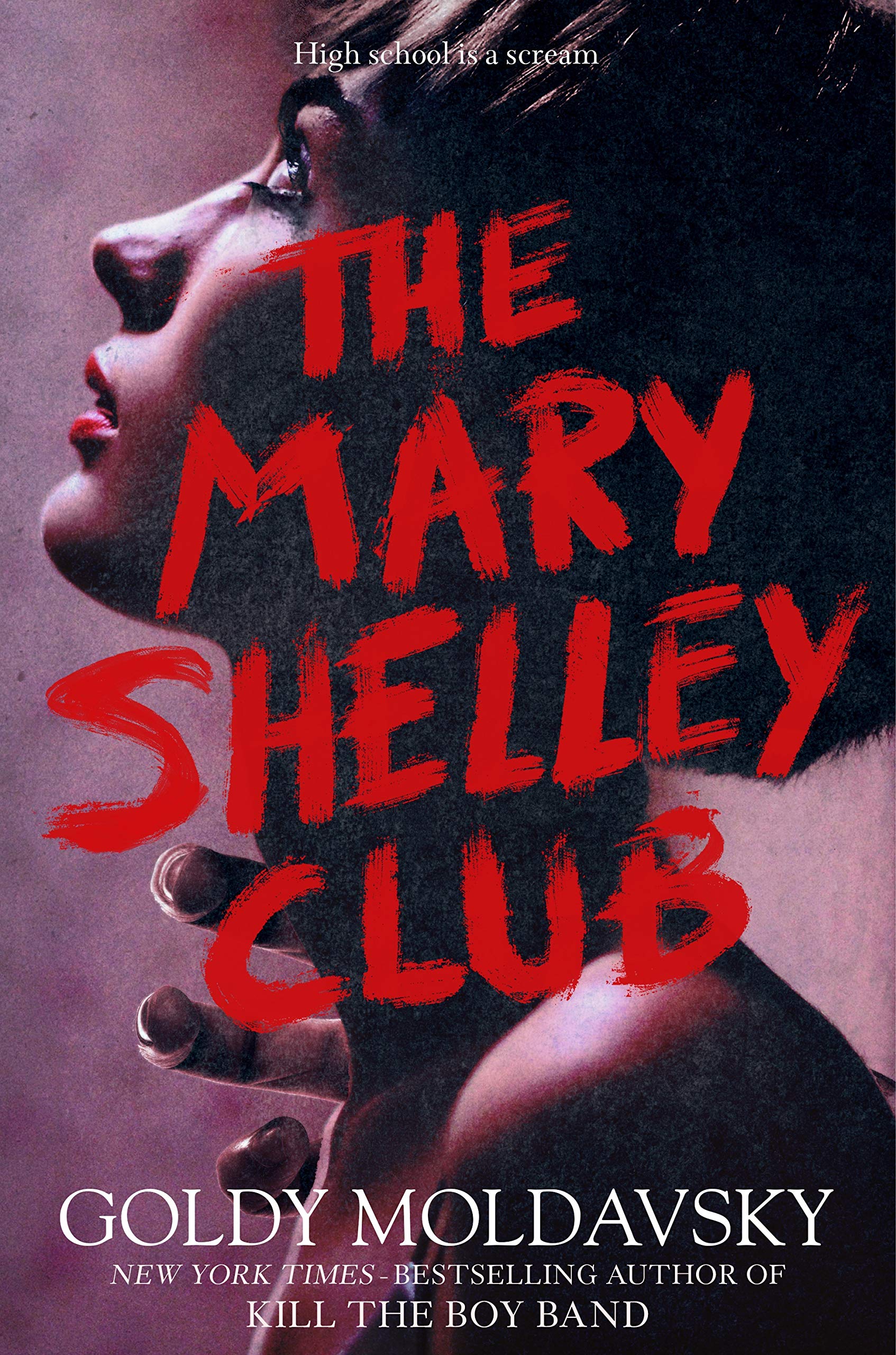 Cover of The Mary Shelley Club by Goldy Moldavsky; side of a woman's face. She is cover in shadows and wearing red lipstick and mascara. A hand is reaching for her neck.