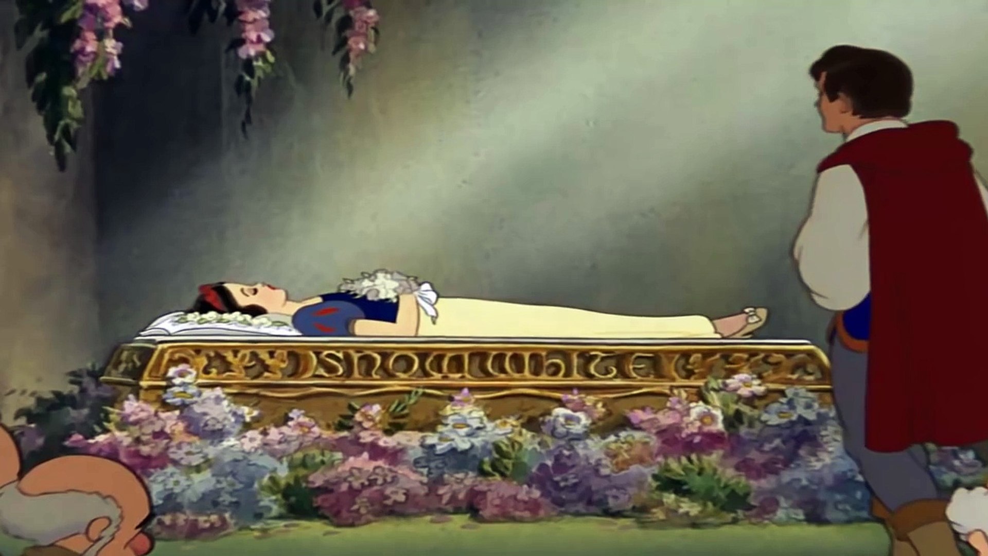 Snow White is laying in a coffin after being poisoned by her step-mother, and her true love, Prince Florian, is approaching her to give her true loves kiss and break the spell to wake her up.