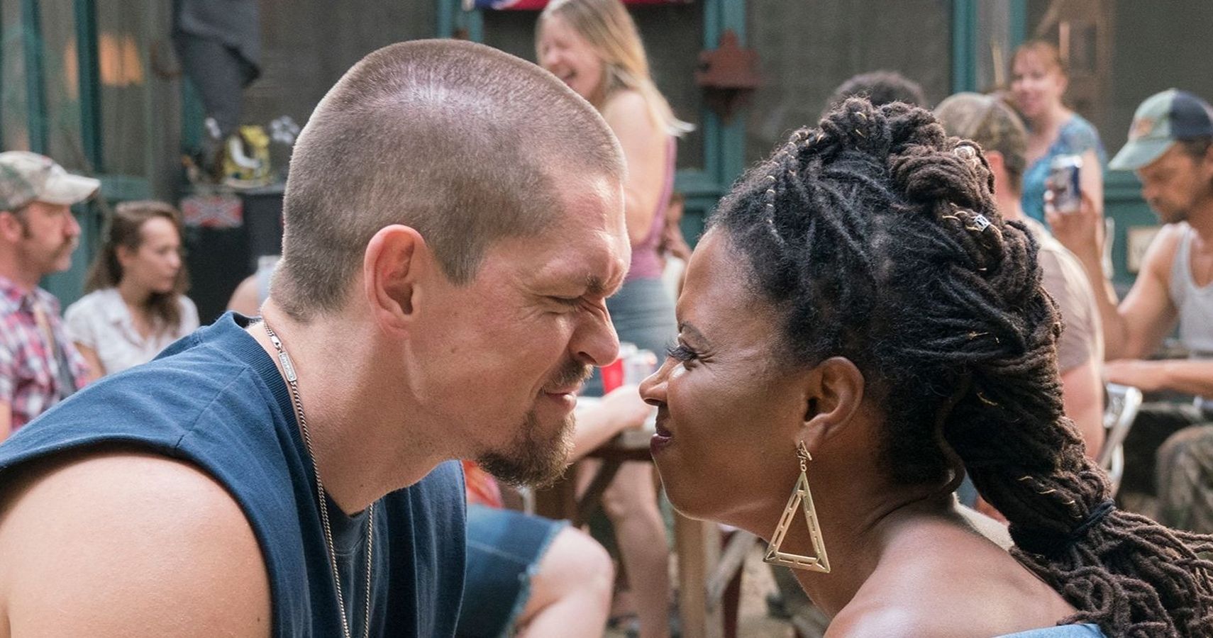 Veronica Fisher and Kevin Ball are making happy, squinty faces at each other while going in for a kiss.