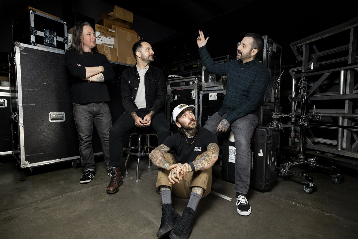 The members of Bayside sit in a room surrounded by music equipment (“Vacancy.” Bayside. 2016. Hopeless Records.).