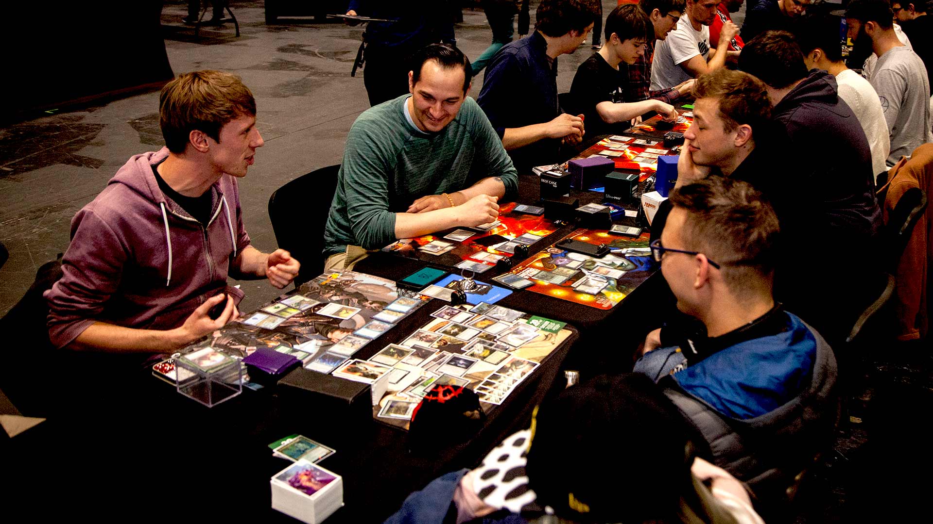 People playing Magic: the Gathering at a tournament table. 