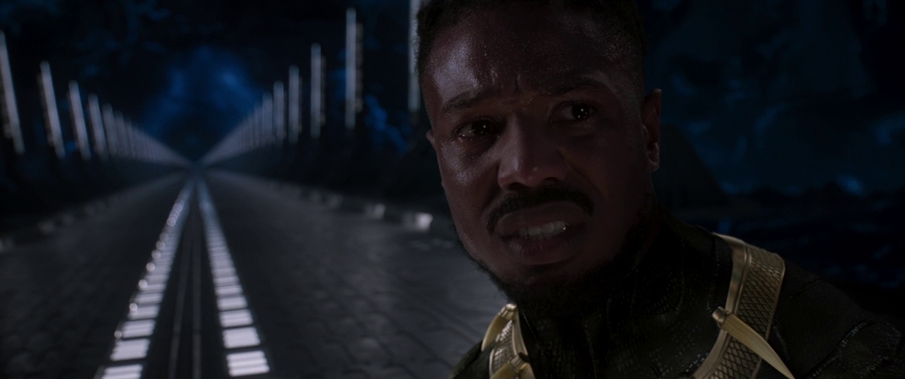 Erik Killmonger gazes in distress fighting T'Challa (off-screen) in Black Panther (2018).