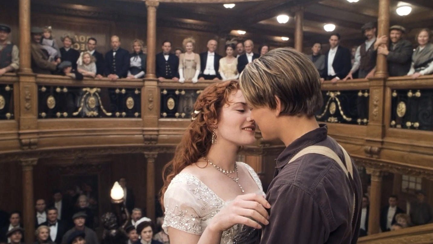 Jack and Rose are nearly kissing and standing in front of a crowd of former Titanic passengers who died the night the ship sank.