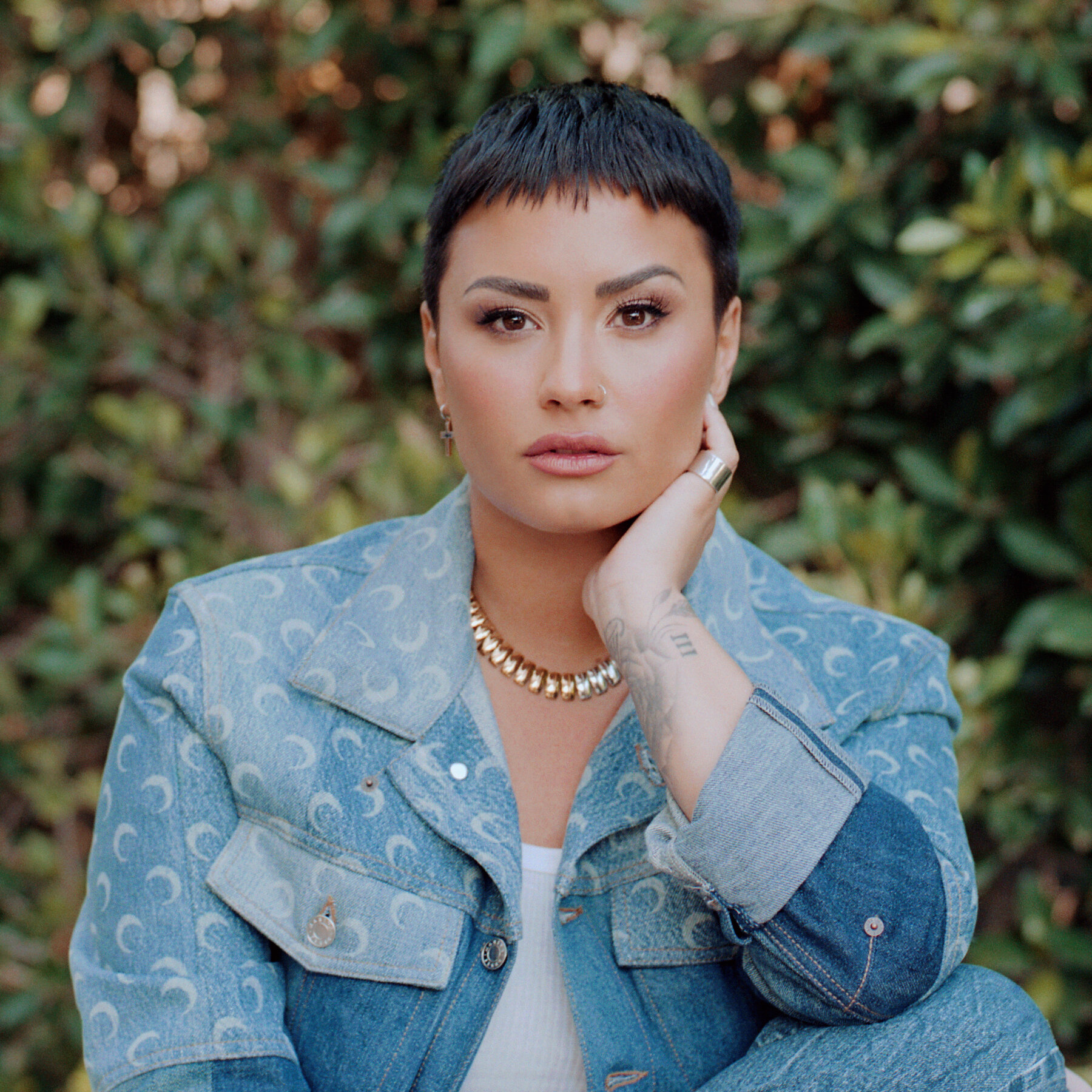 Demi Lovato posing in a jean jacket.